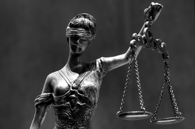 Black and white photo of blind justice statue holding scales
