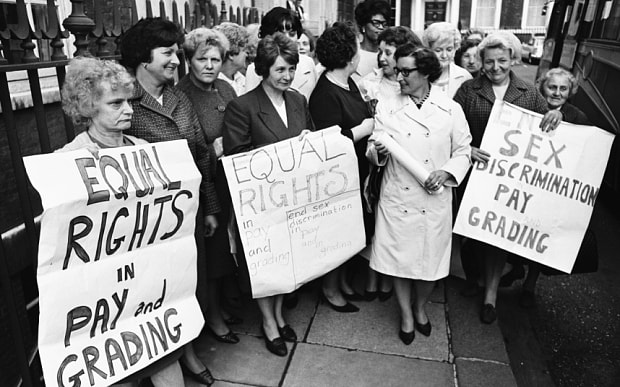 Black and white photo of female Dagenham strikers holding up signs demanding equal rights and equal pay