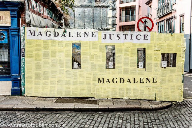 Colour photo of wall covered with papers and the phrase Magdalene Justice