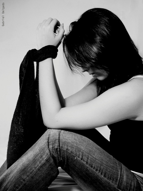 Black and white photo of a woman with cloth tied around her hands